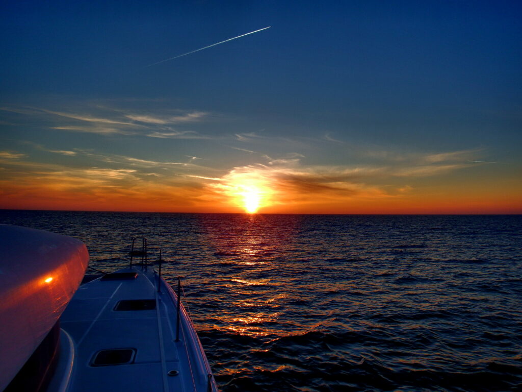 Catamaran sailing into sunset
