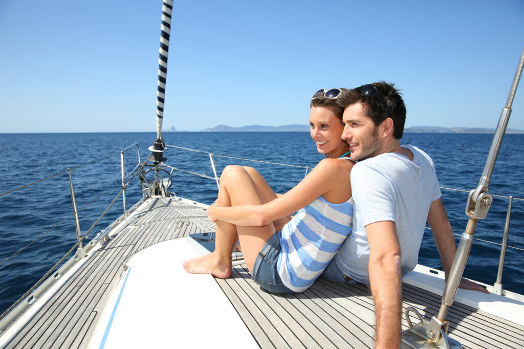Couple stting on sailboat deck looking at sealine