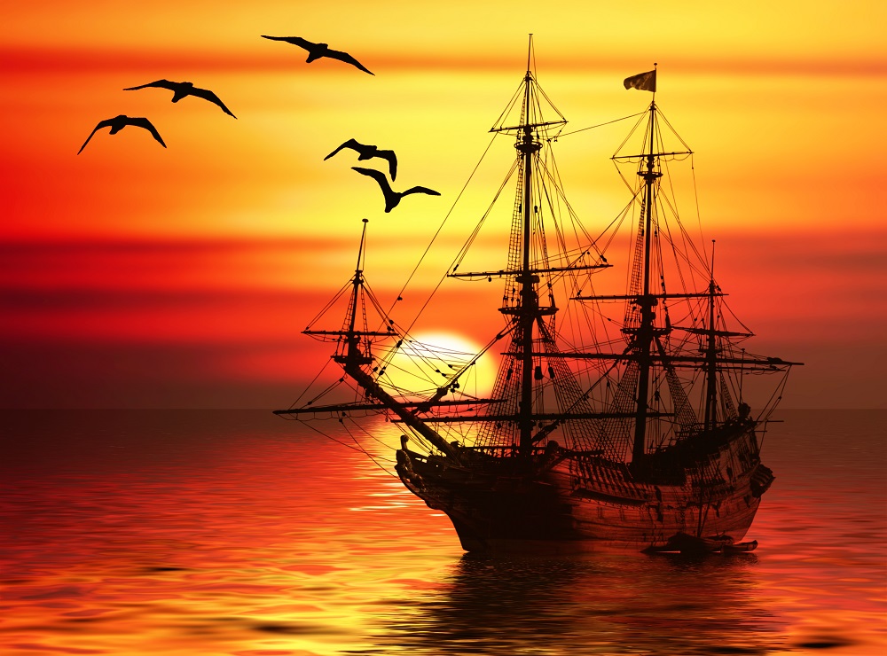Pirate ship sailing in the sunset surrounded by flying seagulls